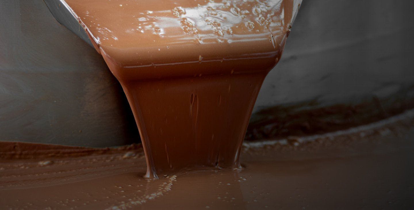 Chocolate being poured into a large tank.