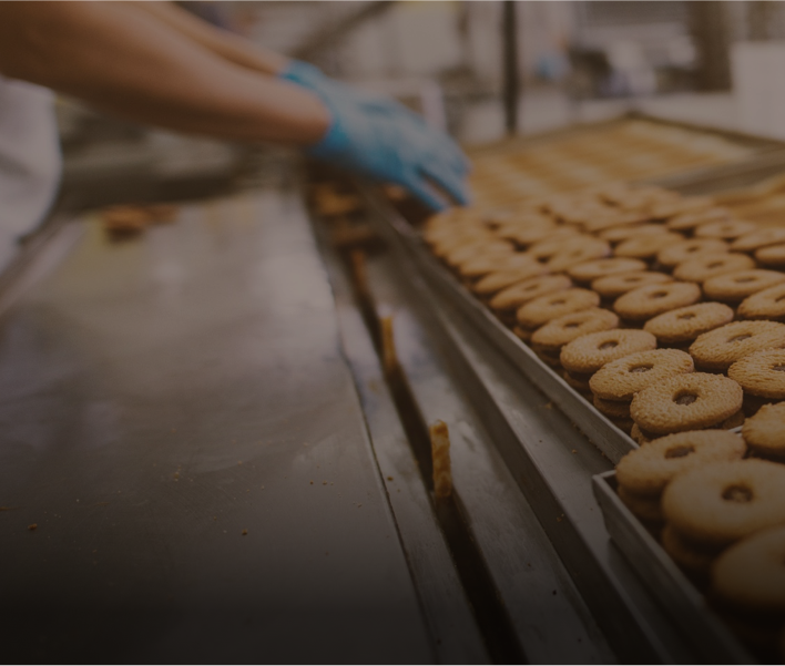 A person making cookies at mass production.